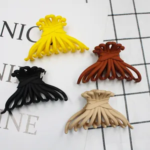 Flat lay of matte candy-colored claw clips in yellow, black, brown and beige tones