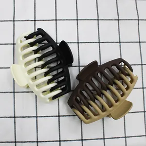 Détail des grandes pinces à cheveux mates de 11cm au design bicolore et ressort métallique