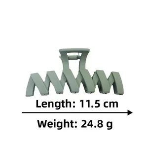Détail d'une grande pince à cheveux mate gris-vert de 11,5 cm avec dents en forme de Z