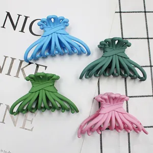 Close-up of colorful matte hair claw clips with octopus design on a textured background