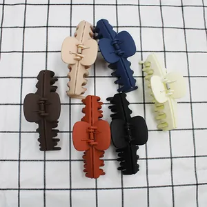Lot de six pinces à cheveux mates de 11 cm aux couleurs variées sur fond à carreaux