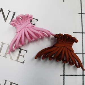 Close-up of pink and brown matte hair claws with a stylish cross-ribbon design
