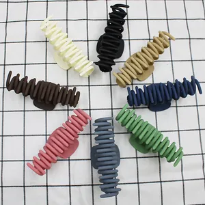 Vue de dessus de huit pinces à cheveux mates de couleurs variées sur un tissu à motifs