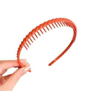 Cerchietto arancione antiscivolo con denti e trama intrecciata per lo styling dei capelli