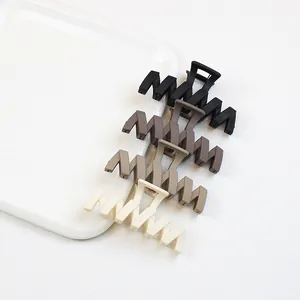 Lot de quatre pinces à cheveux zigzag mates en noir, café et crème sur une assiette
