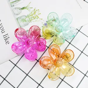 Dettaglio di fermagli per capelli a fiore in rosa, blu e arancione con glitter