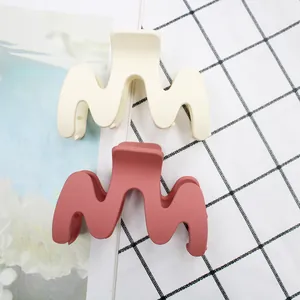 Detail of matte wave hair claws in cream white and dusty rose colors for women