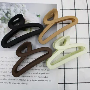 Close-up of four matte-finished large hair claws in black, coffee, khaki and green colors