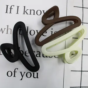 Three matte hair claw clips in black, brown, and cream green with hollowed-out design