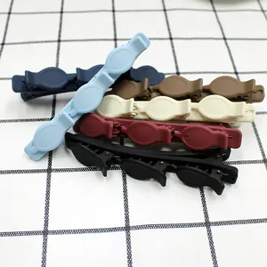 Macro detail of six matte braided duckbill clips for styling side hair and bangs