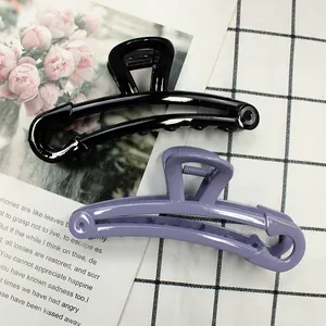 Detailed view of large black and purple hollow hair claws with glossy finish and metal springs