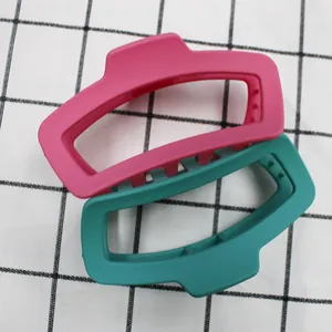 Dettaglio di grandi fermagli per capelli opachi colorati in rosso rosa e verde
