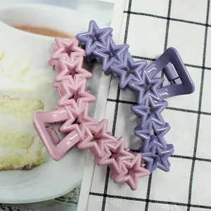Detail view of pink and purple star-shaped claw clips with glossy macaron finish