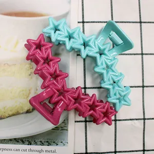 Detail of star-shaped hair clips in blue and pink with durable metal springs
