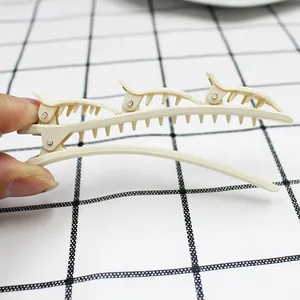 Detail of cream-colored multi-layer hair clip with three mini alligator clips for styling