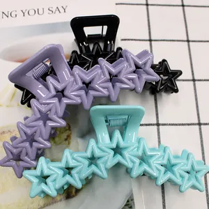 Close-up of star-shaped large hair claws in purple, black, and light blue colors