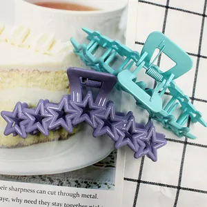Matte purple star-shaped and teal geometric hair claws for women in a lifestyle setting