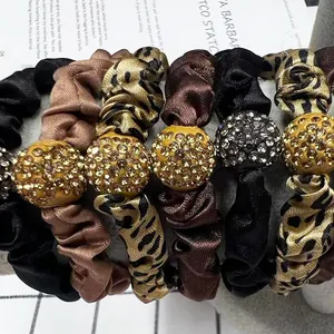 Detail of six satin scrunchies with leopard print and rhinestone ball ornaments