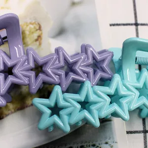 Close-up of star-shaped macaron hair claws with hollow design and metal spring detail
