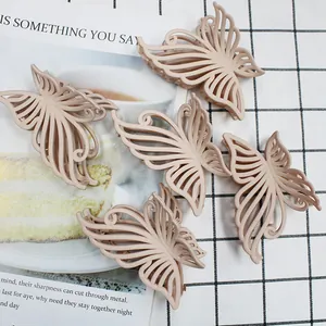 Five 10cm vintage matte butterfly hair claws in beige scattered on a checkered background