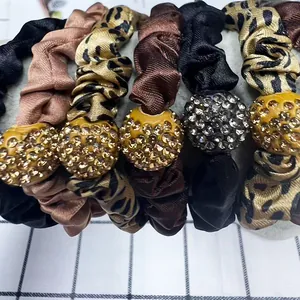 Elegant rhinestone scrunchie set with leopard print and satin fabric on a display stand