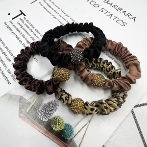 Set of four satin scrunchies in leopard print and solid colors with rhinestone accents