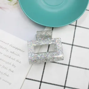 Dettaglio di un fermaglio per capelli quadrato con glitter laser colorati in resina