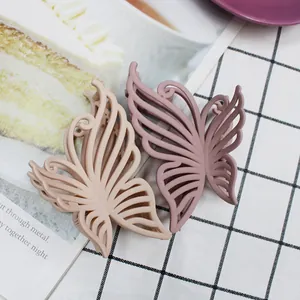 Close-up of matte butterfly hair claws with hollow design in beige and purple colors