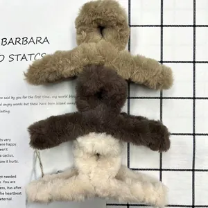 Tres pinzas para el cabello de felpa en caqui, marrón y beige sobre un fondo moderno