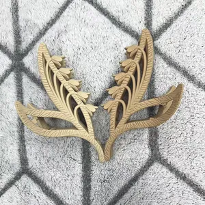 Détail de pinces à cheveux muguet en métal doré mat sur un support en tissu peluche