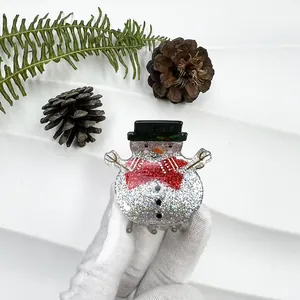 Detail of cute snowman hair claw with silver glitter finish and holiday bowtie