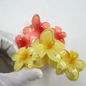 Dettaglio della molletta per capelli a plumeria sfumata con petali in resina gialla e rosa