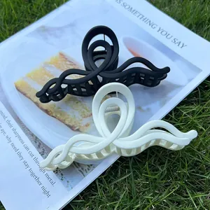 Detail shot of matte black and cream wave hair claws on a magazine in natural light