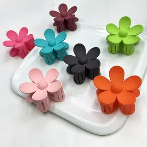 Set di mollette per capelli a fiore opaco in 7 colori pastello su piano di marmo