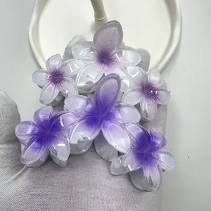Dettaglio delle mollette per capelli a forma di plumeria con sfumatura viola moda