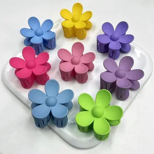 Set di 8 mollette per capelli a fiore opaco in colori pastello su un vassoio di ceramica