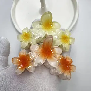 Dettaglio di fermagli per capelli floreali con design Plumeria sfumato in giallo e arancio