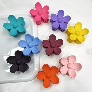 Dettaglio di nove mollette per capelli a fiore opaco in colori pastello su vassoio