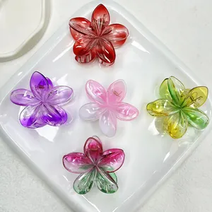 Détail de pinces à cheveux en forme de fleur en résine colorée avec dégradés sur plateau