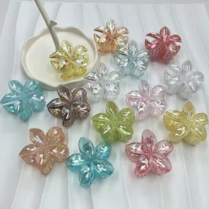 Close-up of iridescent plumeria flower hair claws in assorted macaron colors