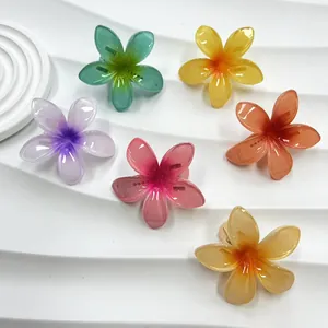 Dettaglio di sei mollette per capelli in resina traslucida a forma di fiori di frangipane