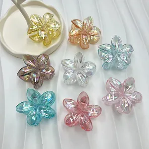 Close-up of colorful iridescent flower hair claws with a metallic spring mechanism