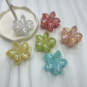 Iridescent plumeria flower hair claws in multiple colors for seaside vacation styling