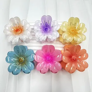 Dettaglio di sei mollette per capelli a forma di fiore di plumeria in vari colori sfumati