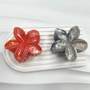 Dettaglio di pinze per capelli a forma di fiori di plumeria marmorizzati rossi e blu