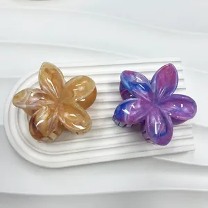 Dettaglio dei fermagli per capelli a fiore di frangipane con motivo marmo ambra e viola
