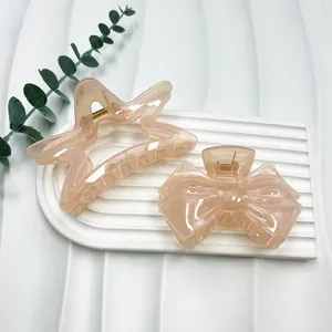 Detail of star and bow hair clips in apricot pink resin with pearl texture finish