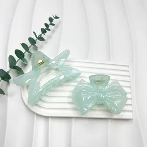 Detailed close-up of marble pattern star and bow hair claws on a decorative tray