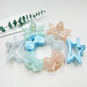 Close-up of pastel macaron-colored star and bow hair claws with metal spring clips
