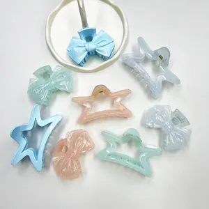 Flat lay of pastel bow and star hair claws in assorted pearlescent acrylic colors